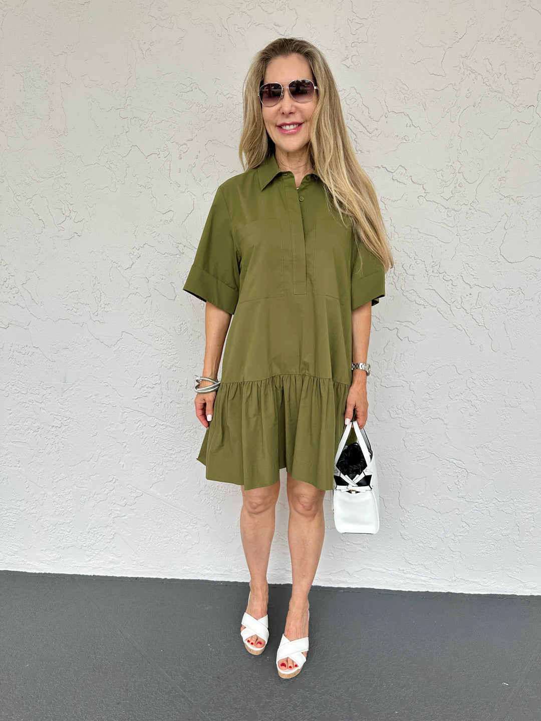 Simkhai Cris Short Sleeve Shirt Dress in Army Green,  collared dress made from 100% cotton with button-front closure, chest pockets, elbow-length sleeves, and flounce hem