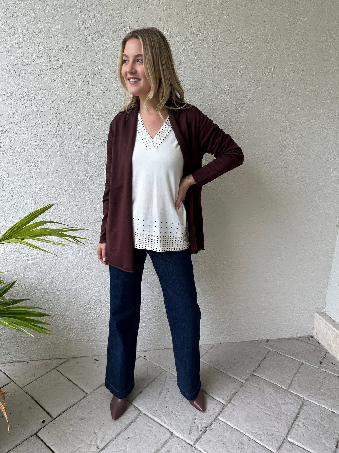 Leo & Ugo Rhinestone Grommet V-Neck Top in White layered with BK Long Open Cardigan in Espresso, paired with MAC Indigo Dark Dream Wide Jeans, all available at Barbara Katz