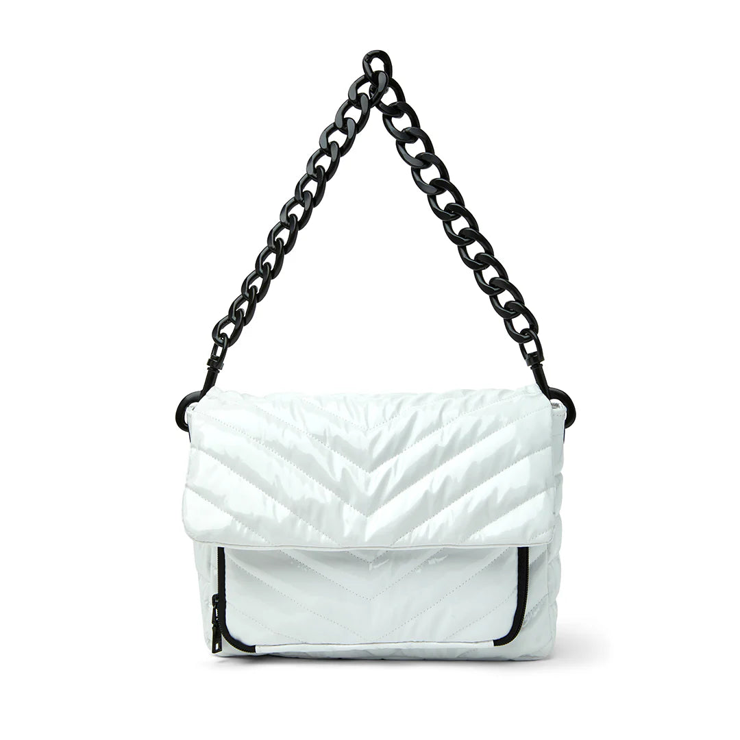 Think Royln The Muse Crossbody Bag in White Patent with metallic chain handle, featuring lightweight quilted polyfill, top zipper closure, and flap top with single snap closure