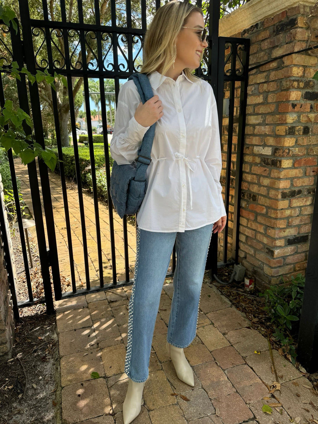 Ba&sh Aply Shirt in Blanc paired with Frame Atelier Le Jane Crop Denim Jeans in Daylight Pearl, Le Specs Neptune Deux Sunglasses, Vee Collective Porter Messenger in Denim - all available at Barbara Katz