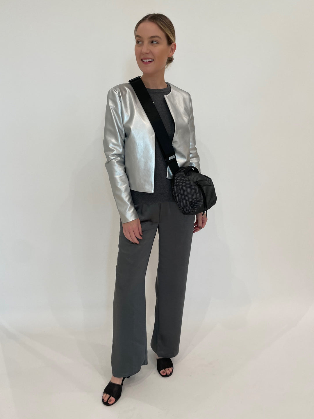 J Society Silver Metallic Collarless Jacket with J Society Gunmetal Satin Pocket Sweatshirt underneath, paired with J Society Gunmetal Satin Pants, Daniella Lehavi Bonnie Crossbody Bag in Grey available at Barbara Katz