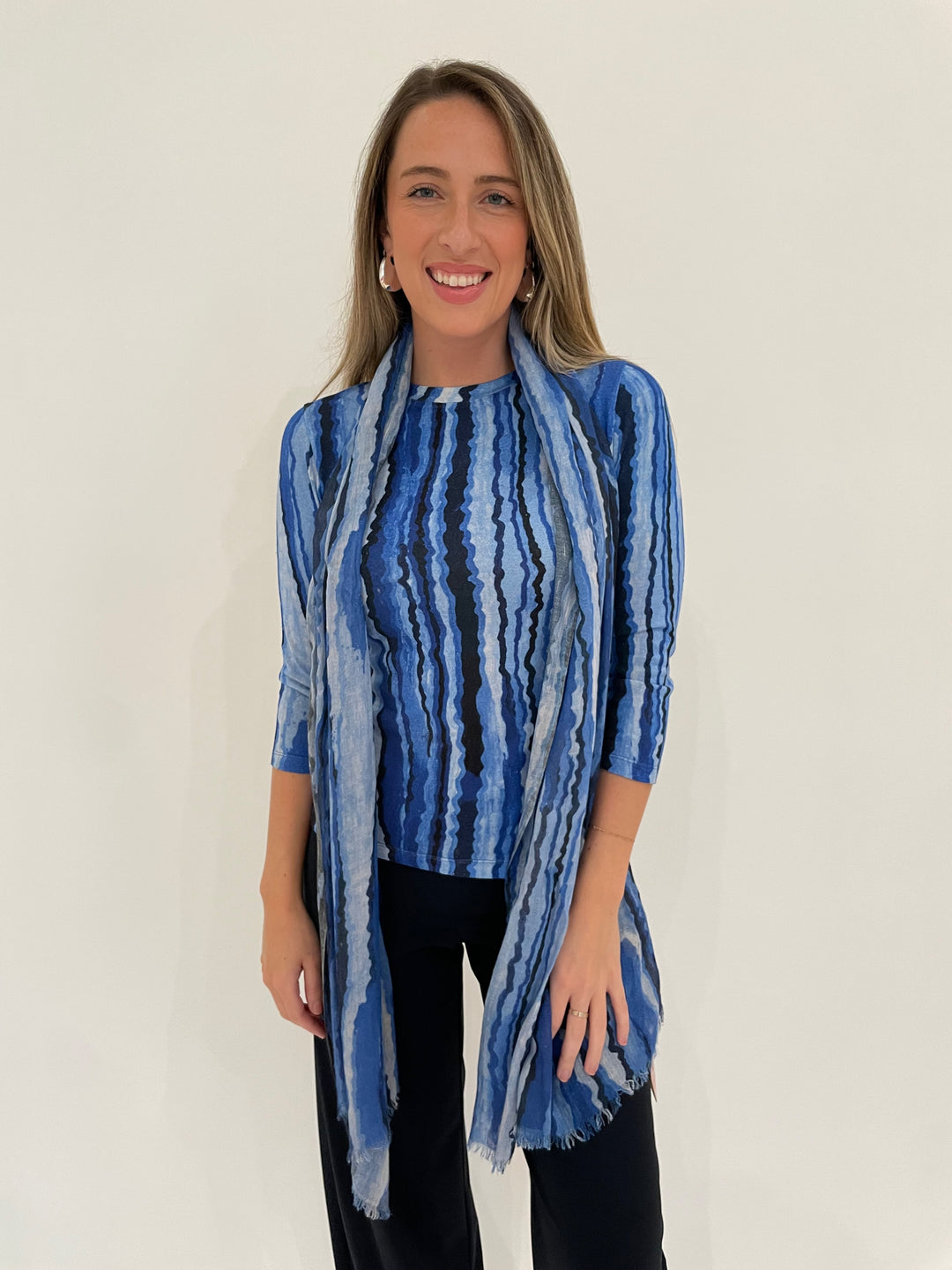 Pashma Contoured Bamboo Silk Lines T-Shirt in Blue with Contoured Lines Scarf, paired with Raffaello Rossi 7/8 Sally Pants in Marine, BK Bianca Puffy Triangle Open Hoop Earrings in Silver - all available at Barbara Katz