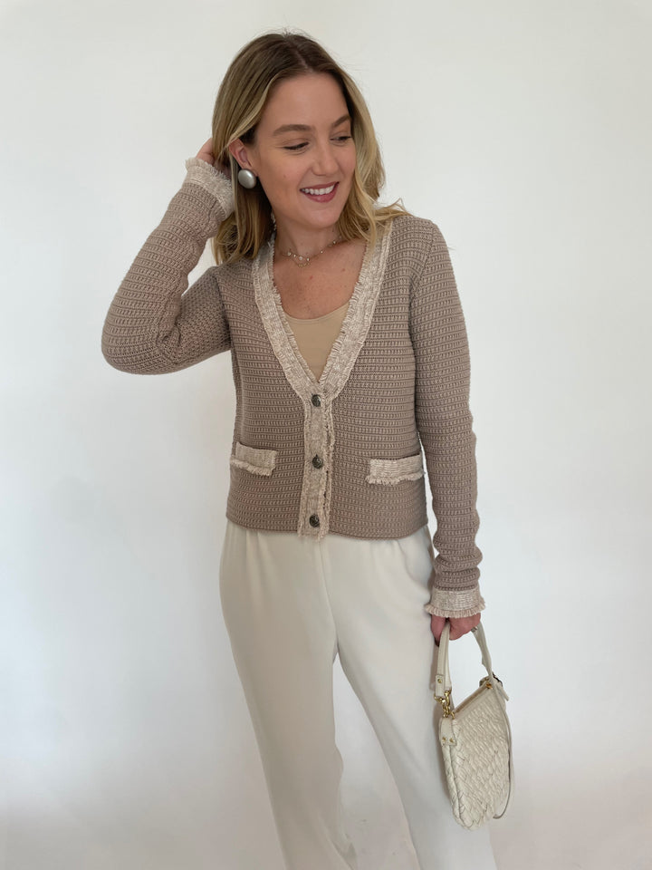 Autumn Cashmere Fringed Trimmed V-Neck Jacket in Sandalwood Combo paired with Peace of Cloth Jules Paramount Knit Pants in Oyster, Pono Mollie Barile Clip Earrings in Silver, Clare V  Petit Moyen Messenger Bag in Cream Puff Woven available at Barbara Katz