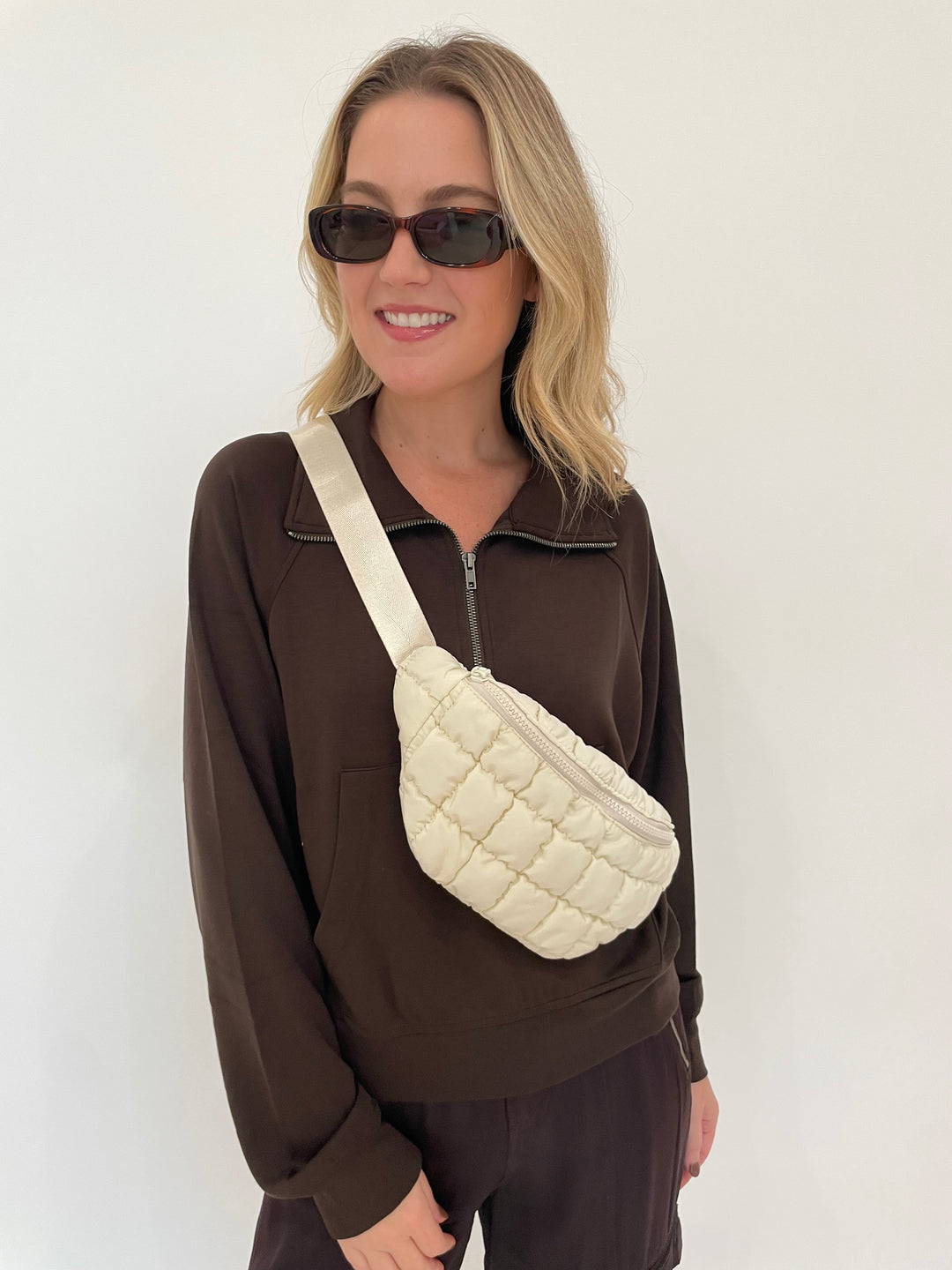 BK Caroline Half Zip-Up Collar Sweatshirt in Chocolate Brown with Le Specs Unreal! Sunglasses in Toffee Tort, Sol and Selene Resurgence Puffer Belt Bag in Ivory available at Barbara Katz