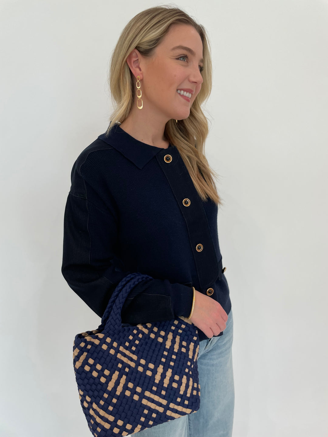 Leo & Ugo Denim Knit Jacket in Navy paired with Pistola Ryder High Rise Cuffed Jeans, Dean Davidson Gold Bleecker Statement Drop Earrings, Sol and Selene Sky's The Limit Small Crossbody Bag in Navy/Nude - all available at Barbara Katz