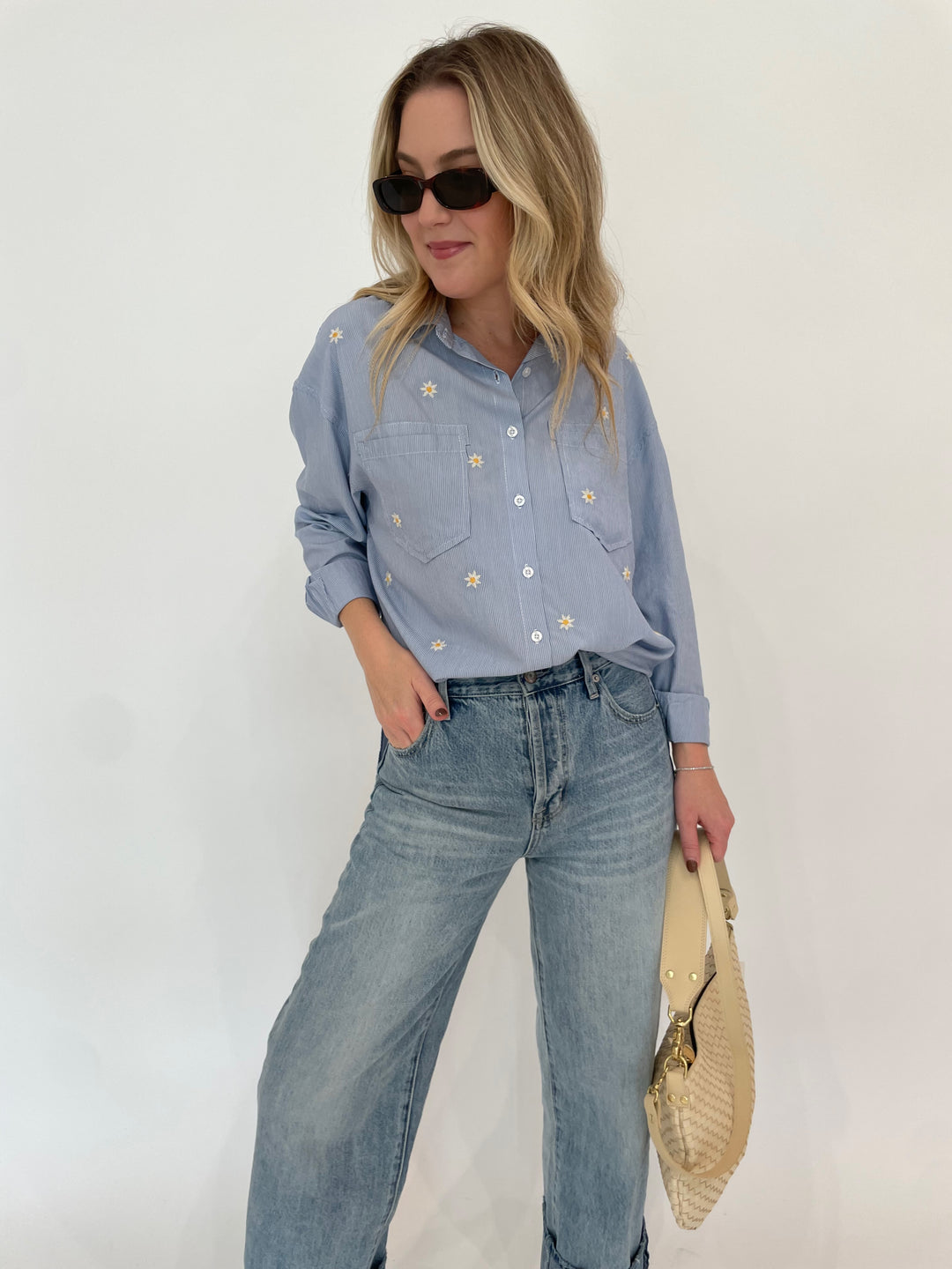 BK Fresh Flower Shirt in Blue Stripe paired with Pistola Ryder High Rise Cuffed Jeans in Essex, Le Specs Unreal! Sunglasses in Toffee Tort, Clare V Moyen Messenger Bag in Cream Woven Checker available at Barbara Katz