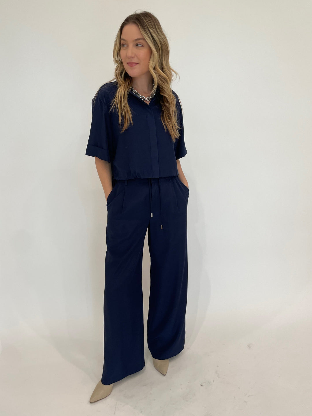 Simkhai Ryett Short Sleeve Cropped Shirt in Midnight paired with matching Sydnie Pleated Pants in Midnight, Pono Barile Mini Bike Chain Necklace in Silver available at Barbara Katz