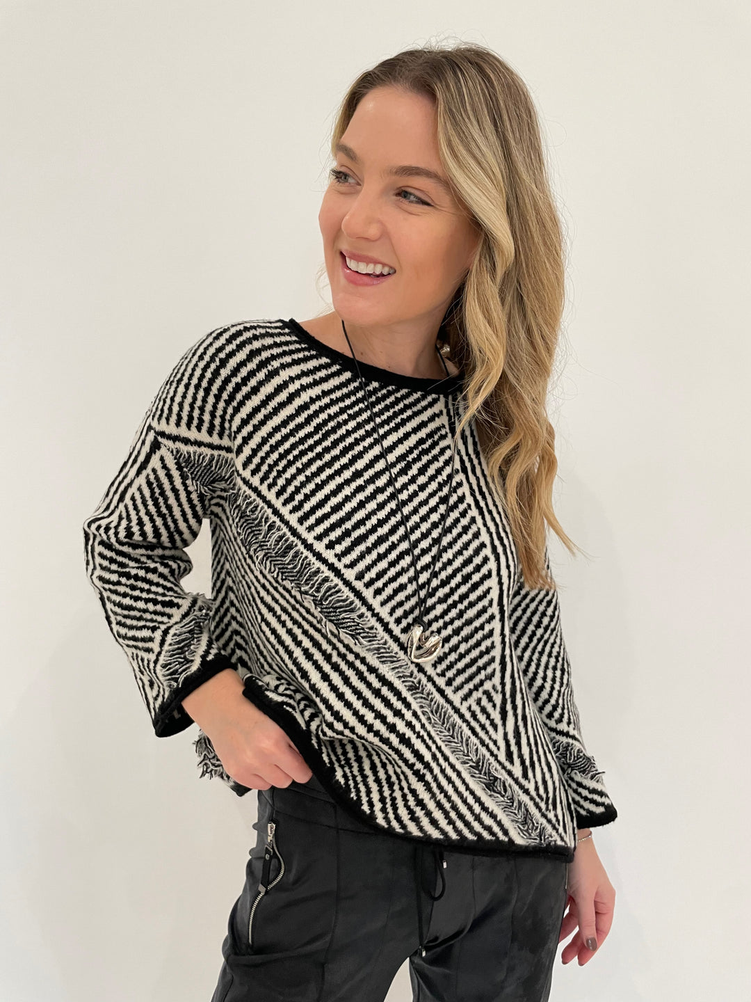 LIV by Habitat Gulia Stripe Fringe Pullover Sweater in Black/White with Paula Rosen Jewelry Small Heart Silver With Leather Cord Necklace available at Barbara Katz