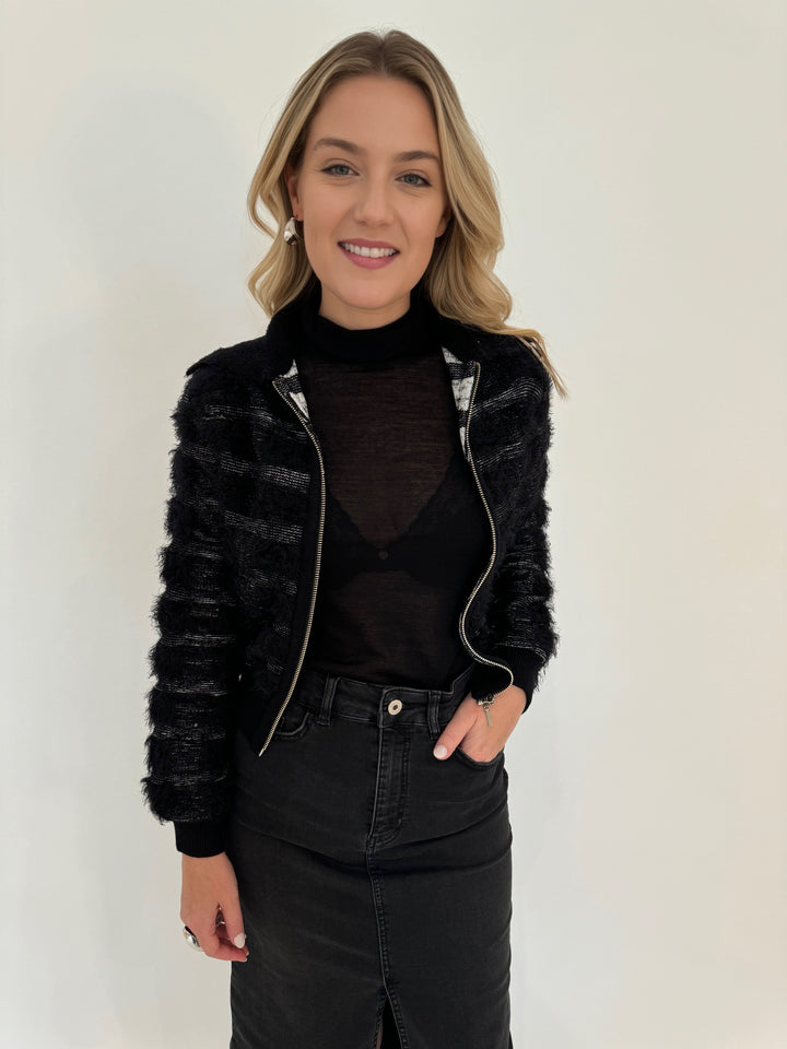 Maria Pavan Ellie Fringe Check Zip Up Sweater in Black/White with Aldomartins Black Norin Top underneath, paired with Elliott Lauren Black Jean Midi Skirt, all available at Barbara Katz