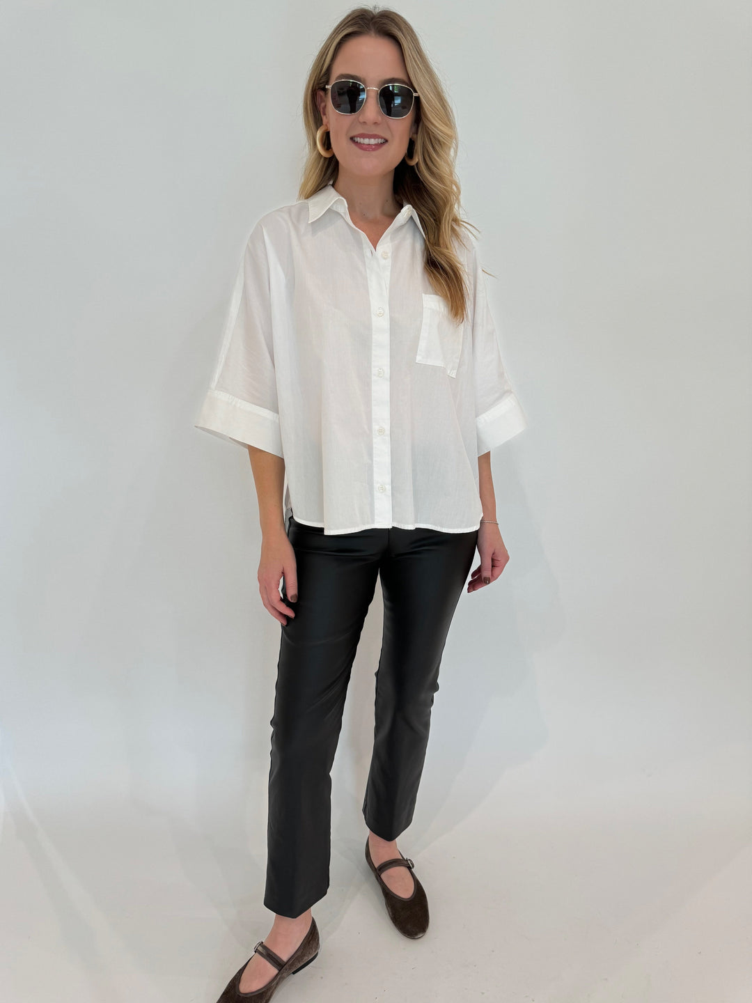 Citizens of Humanity Claire Origami Shirt in White paired withElliott Lauren Coated Bengaline Pants in Black, Le Specs Neptune Deux Sunglasses - all available at Barbara Katz