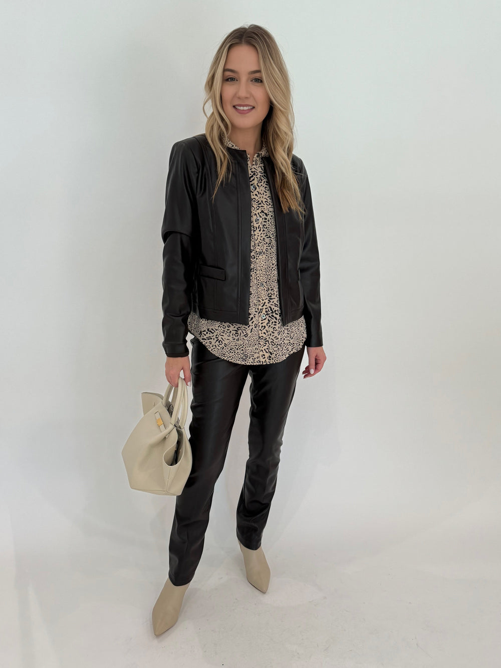 Peace of Cloth Rian Faux Leather Coco Jacket in Brown with Rails Kate Shirt in Sand Cheetah Print, paired with Peace of Cloth Jilian Faux Leather Slim Jeans, bag DeMellier The Midi New York Tote in Off White, all available at Barbara Katz