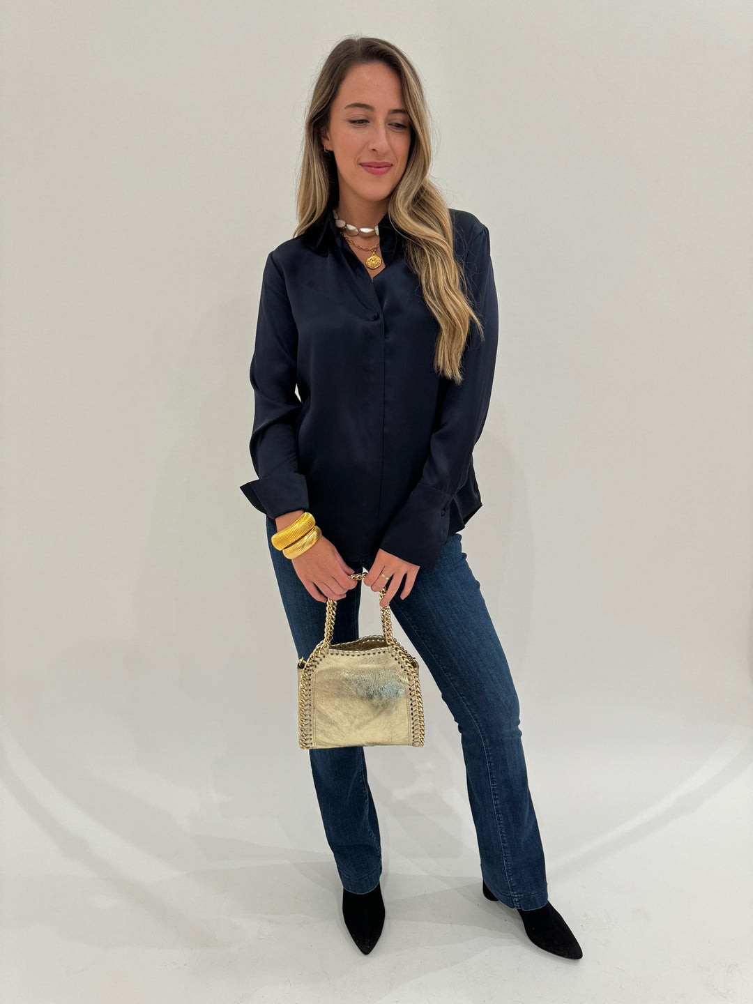 Catherine Gee Daria Silk Shirt in Midnight paired with MAC Denim Dream Boot Jeans in Medium Blue, Lizzie Fortunato Pas De Deux Necklace, BK Gold Cobra Cuff and Bracelet, BK Luxe Metallic Leather Bag in Gold - all available at Barbara Katz
