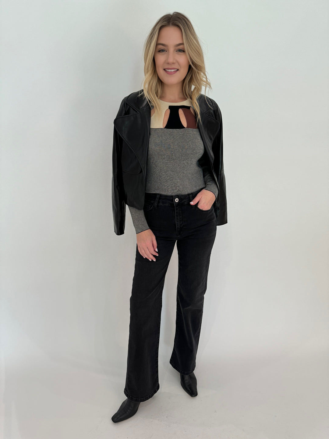 Aldomartins Kamuk Top in Grey layered with Adroit Atelier Ninon Vegan Leather Jacket, paired with Elliott Lauren Athena Wide Leg Jeans, all available at Barbara Katz