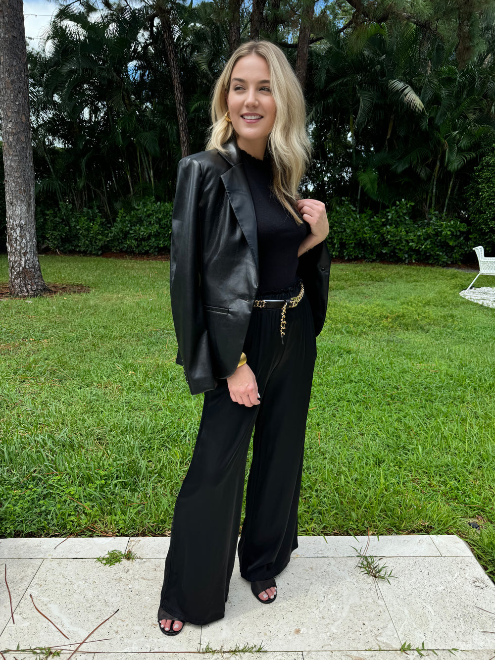 Oui Luna Ruffle Edge Short Sleeve Sweater in Black layered with Adroit Atelier Black Ninon Vegan Leather Jacket, paired with BK Black Italian Silky Palazzo Pants, all available at Barbara Katz