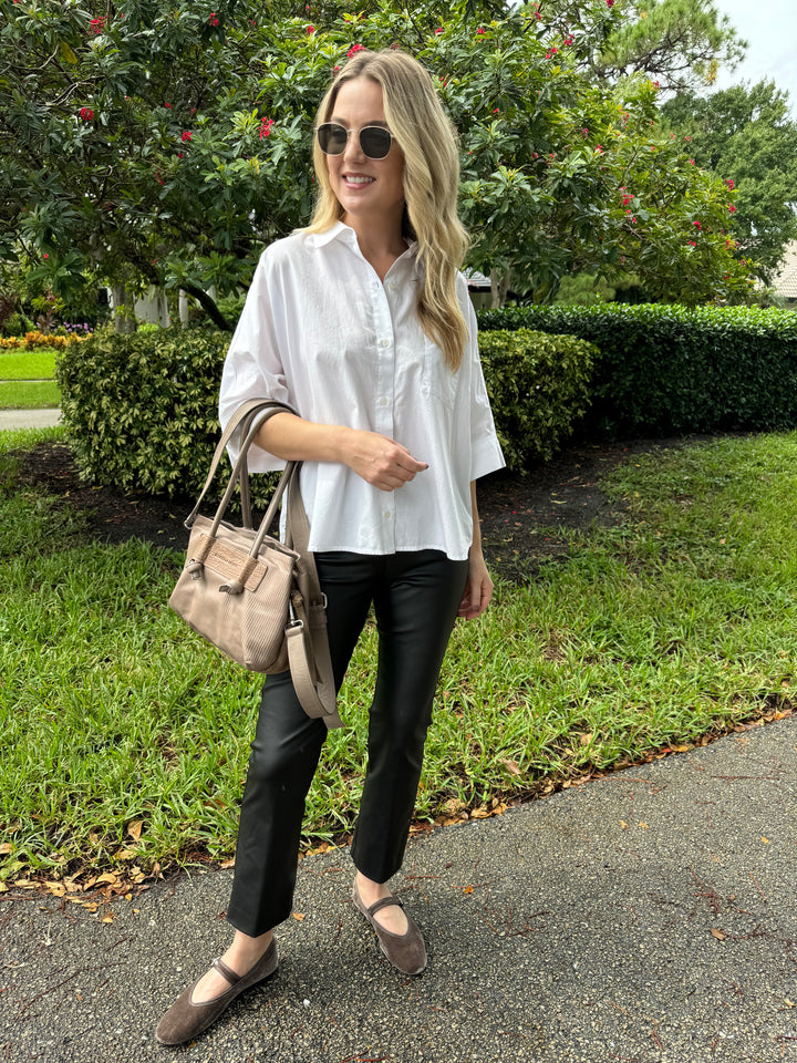 Citizens of Humanity Claire Origami Shirt in White paired with Elliott Lauren Coated Bengaline Pants in Black, Le Specs Neptune Deux Sunglasses, and Daniella Lehavi Eveline Satchel Bag in Mocca Stripes - all available at Barbara Katz