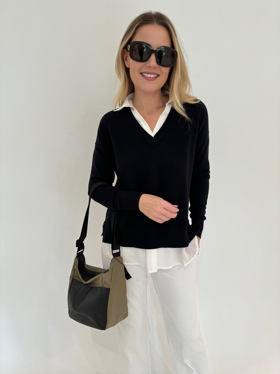 Elliott Lauren Double Layer V-Neck Sweater With Shirting in Black paired with Enza Costa Twill Everywhere Pant in Off White, Daniella Lehavi Porto Small Crossbody Bag in Olive/Black, Le Specs Sunglasses