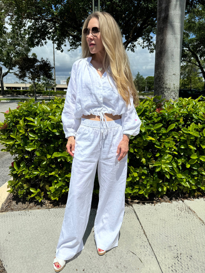 Kerri Rosenthal Palazzo Linen Pants in White, pull-on style pants with elastic waistband, slanted pockets, heart embroidery at the back hip, and drape silhouette with a wider leg