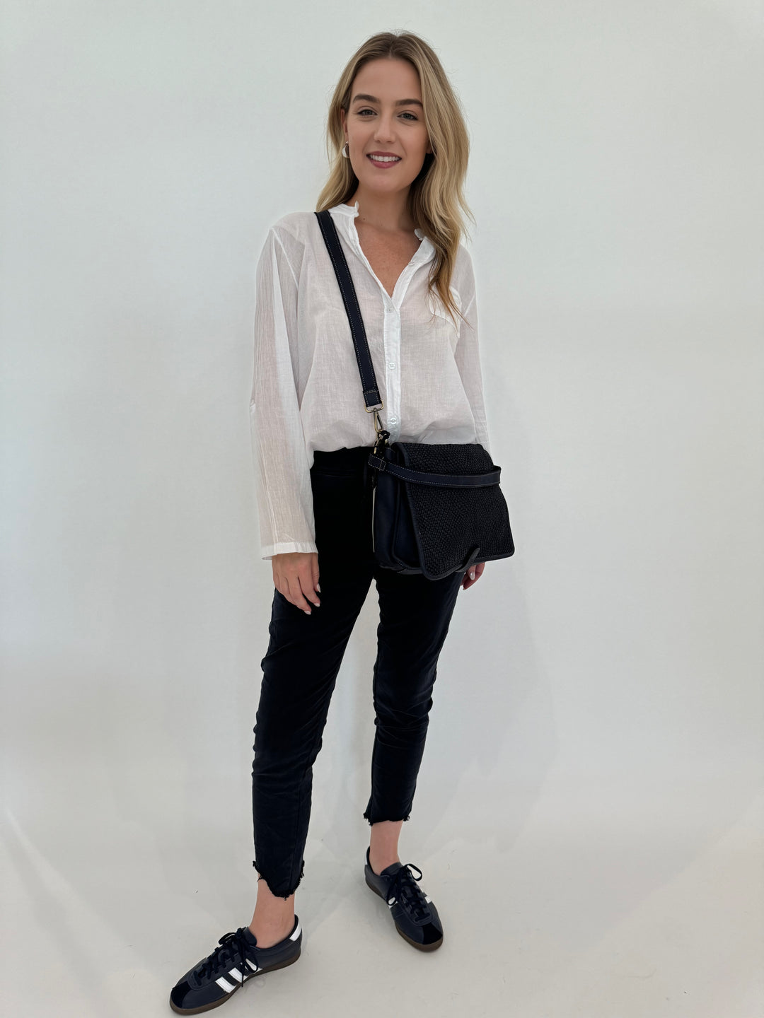 BK Heidi Solid Button Down Cotton Shirt in White paired with Charlie Zip Pocket Crinkle Jogger With Raw Hem in Navy, with Intrecciato Crossbody Bag in Dark Denim, all available at barbarakatzshop.com