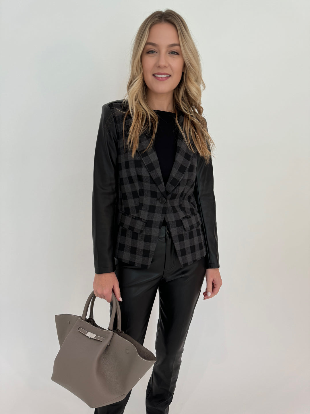 Peace of Cloth Rowan Moto Jacket in Grey/Black with Aldomartins Black Norin Top underneath, paired with Peace of Cloth Black Faux Leather Slim Jeans, bag DeMellier The Midi New York Tote in Stone Grey, all available at Barbara Katz