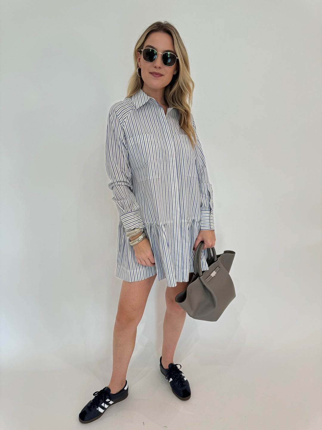 Simkhai Polina Shirt Mini Dress - Cool Gray Stripe with Le Specs Neptune Deux Sunglasses, Alexis Bittar Brut Tube Hoop Earrings in Silver, DeMellier The Midi New York Tote Bag in Stone Grey - all available at Barbara Katz