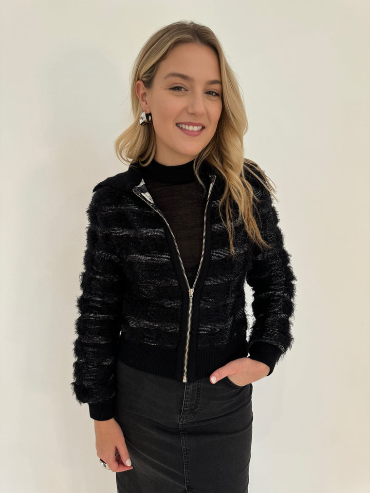 Maria Pavan EllieFringe Check Zip Up Sweater in Black/White with Aldomartins Black Norin Top underneath, paired with Elliott Lauren Black Jean Midi Skirt, all available at Barbara Katz