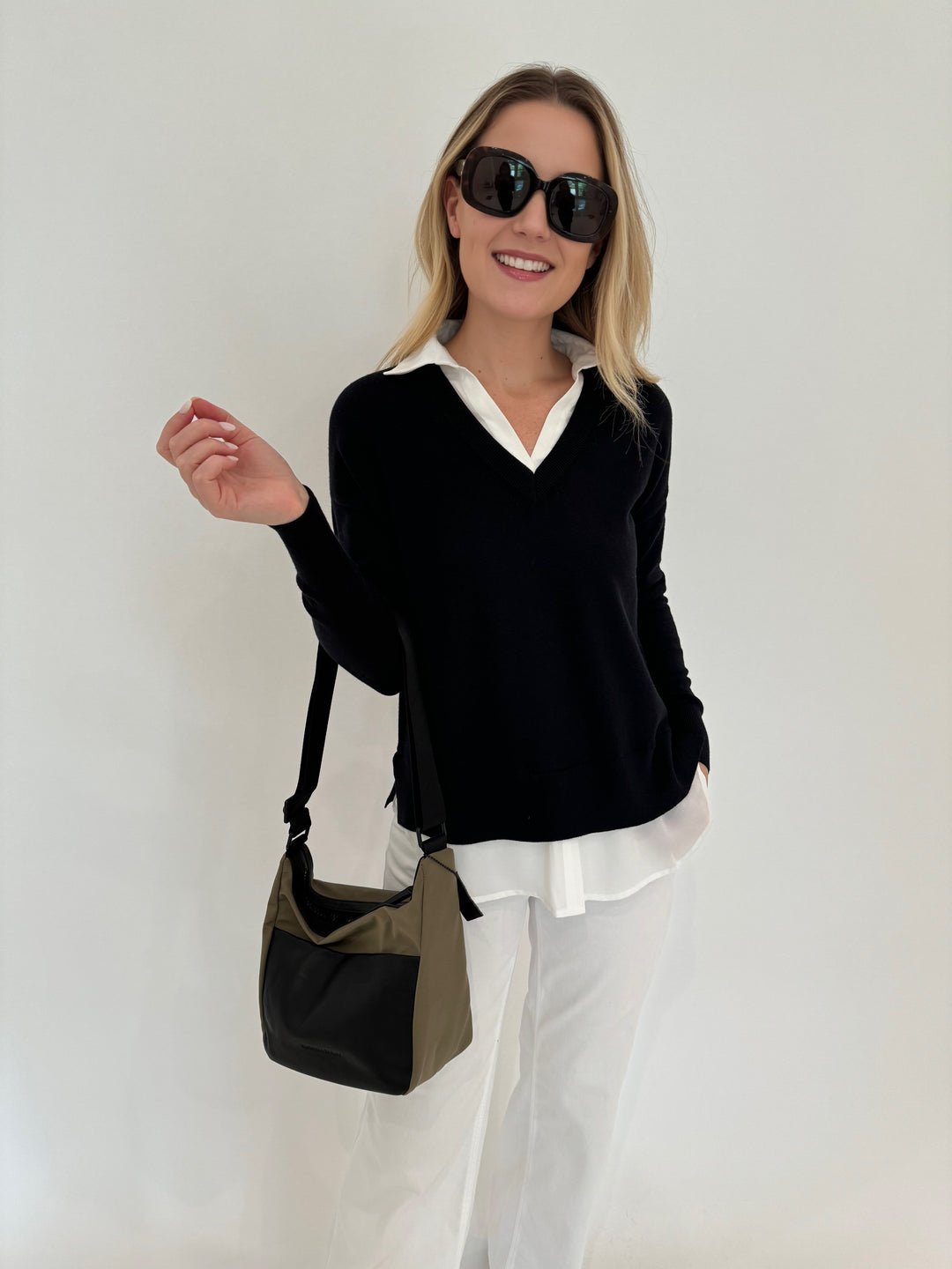 Elliott Lauren Double Layer V-Neck Sweater With Shirting in Black paired with Enza Costa Twill Everywhere Pant in Off White, Daniella Lehavi Porto Small Crossbody Bag in Olive/Black, Le Specs Sunglasses