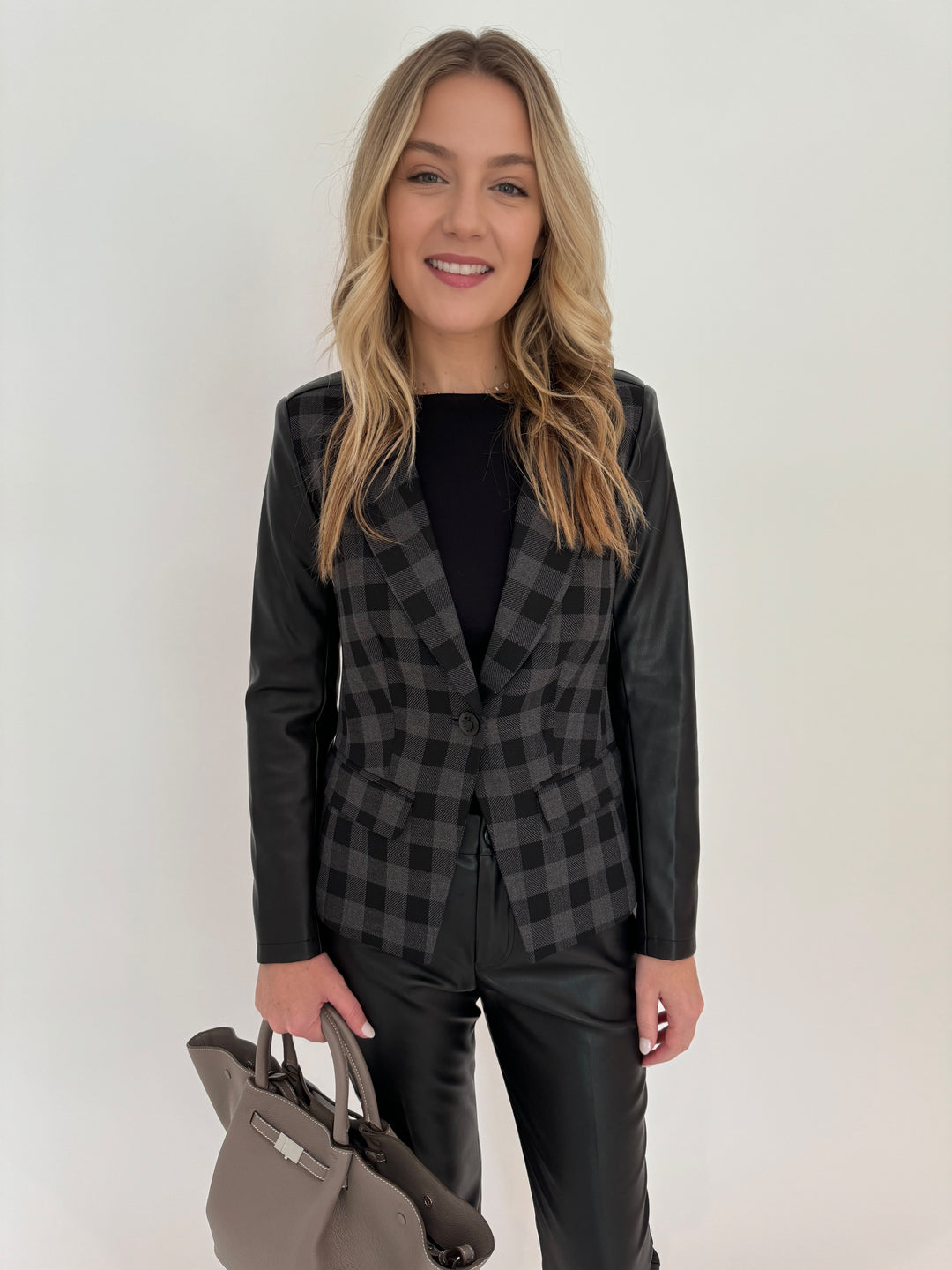 Peace of Cloth Grey/Black Rowan Moto Jacket with Aldomartins Black Norin Top underneath, paired with Peace of Cloth Black Faux Leather Slim Jeans, bag DeMellier The Midi New York Tote in Stone Grey, all available at Barbara Katz