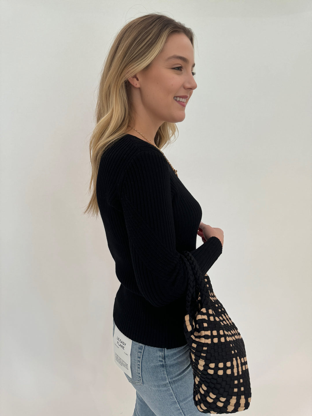 Peace of Cloth Cotton Crew Long Sleeve Jacquard Sweater in Black paired with Frame Le Easy Flare Raw Fray Jeans and Sol and Selene Sky's Small Tote Bag in Black/Nude